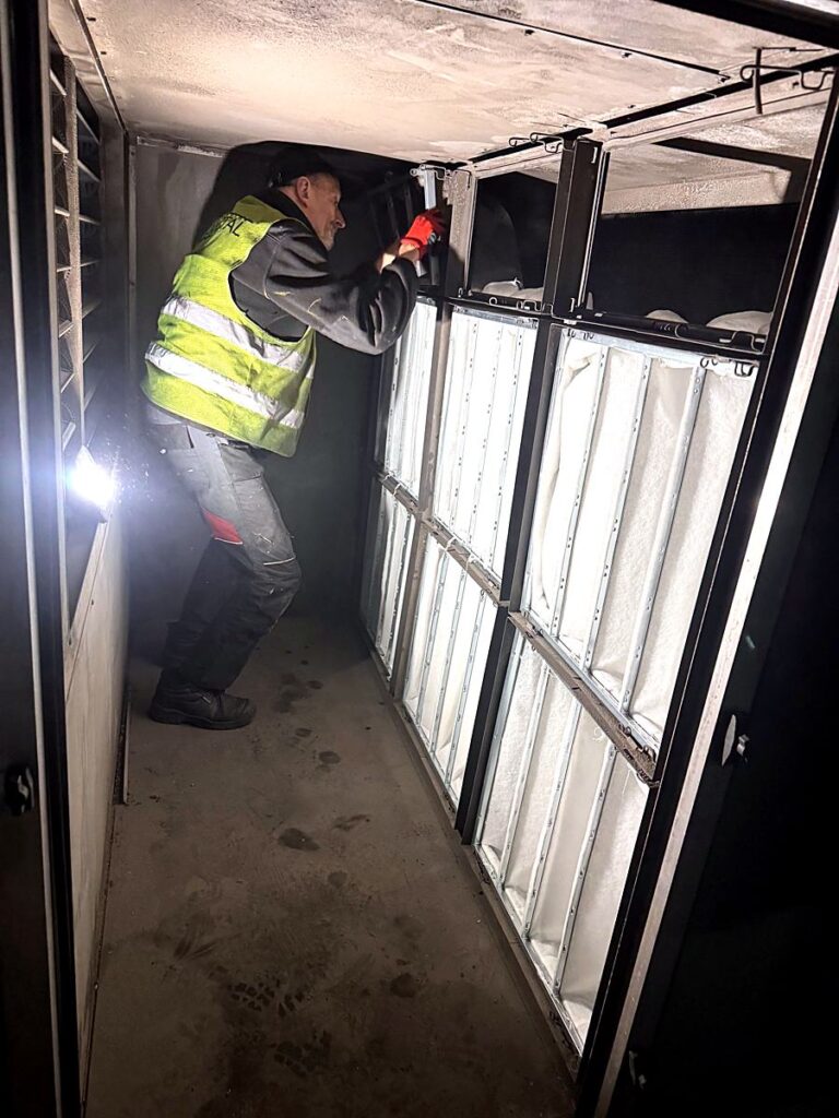 Serwisant w komorze centrali wentylacyjnej przy filtrach kieszeniowych