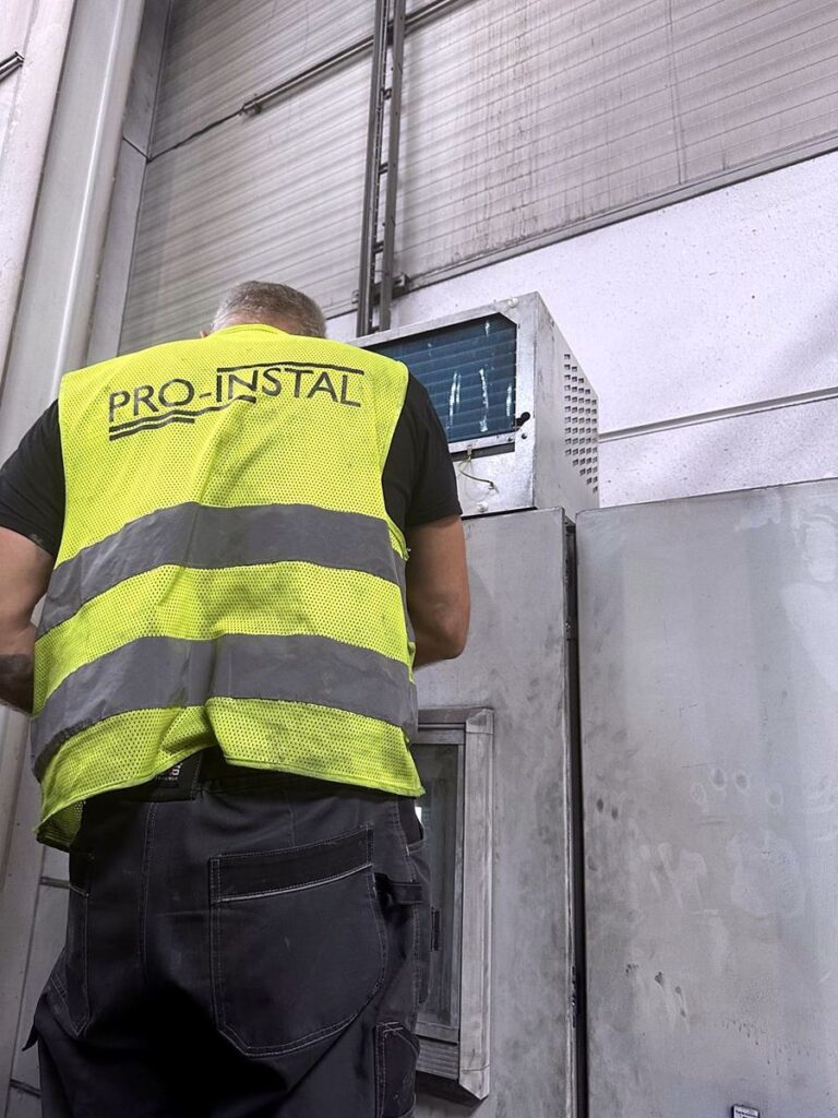 Serwisant przy klimatyzatorze szafy sterowniczej
